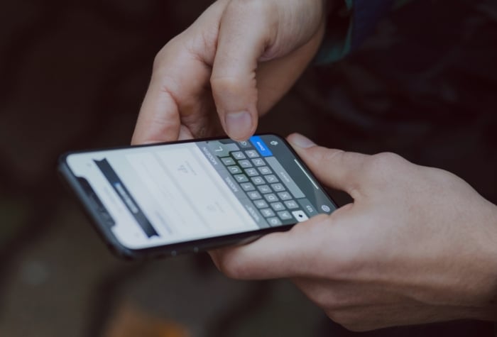 Person hält Mobiltelefon in der Hand und benutzt die Ticket App von 1Tool.